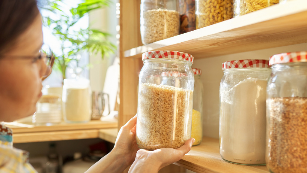 A person holding a jar of rice